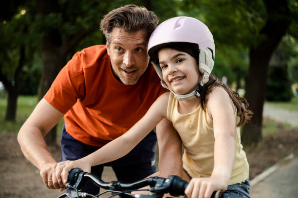 istock Father helping his little daughter to learn cycling 1445857410