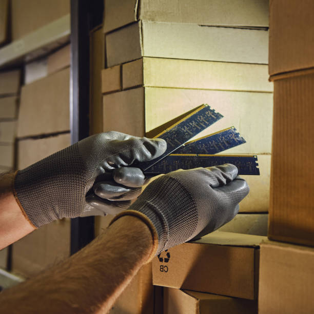 istock Computer chips memory ram in the hands of a man warehouse worker. The crisis of electronics delivery and problems with logistics of technology transport. 1445857462
