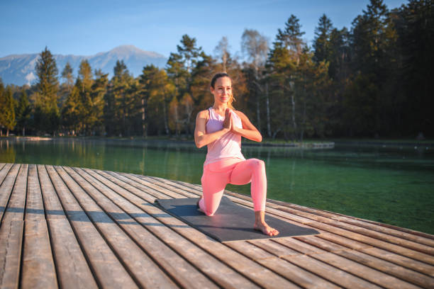 istock Young Woman Doing Yoga Next To An Emerald-Colored Lake 1445859366