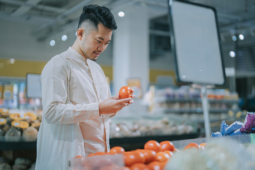 Asian Chinese Man buying tomato in supermarket groceries