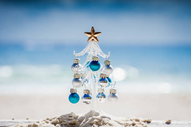 Arbre de Noël en verre sur le sable d'une plage au Mexique. La mer en arrière plan.