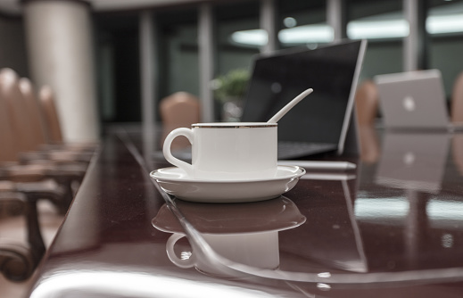 Laptop and coffee cup on conference table