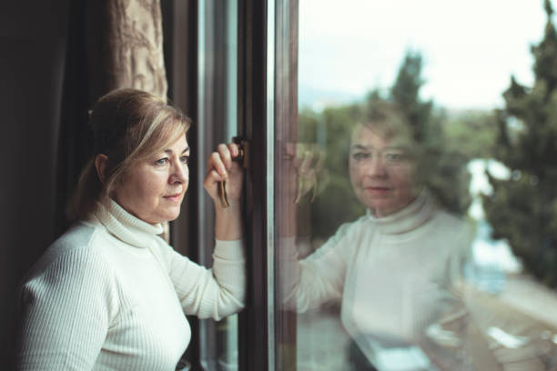 istock Alone woman day dreaming by the window 1445880393