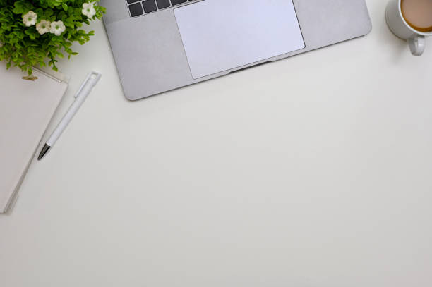 istock Minimal white workspace with laptop, book, pen, coffee cup, decor plant and copy space. top view 1445885215
