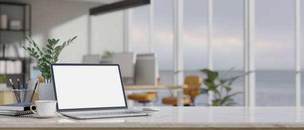 istock Modern office desk workspace with laptop mockup over blurred modern office in the background. 1445885253