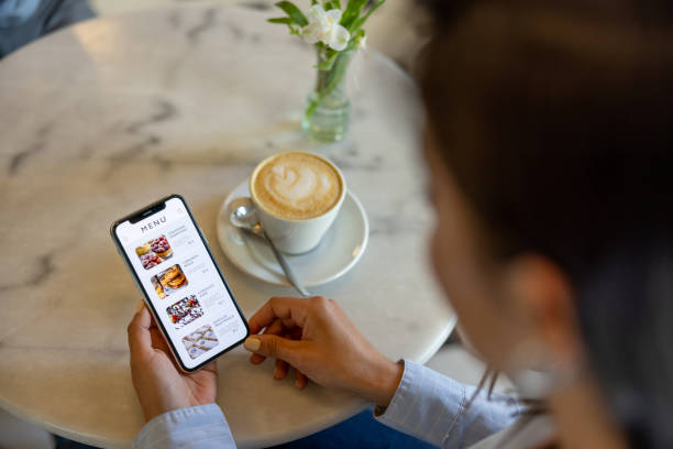 istock Woman at a cafe looking at a digital menu 1445890778