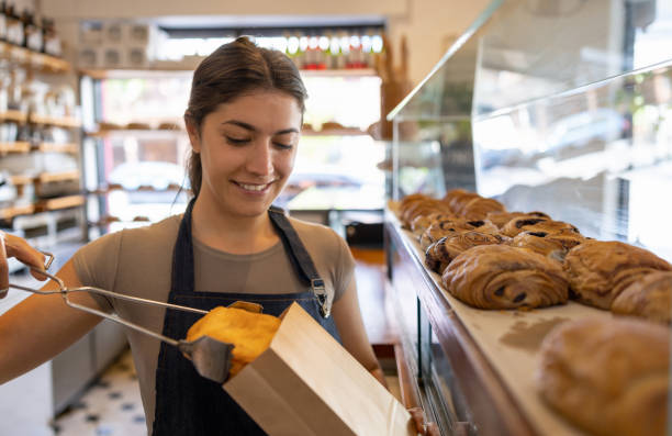 istock Woman working at a cafe and packing some pastries for an order 1445890826