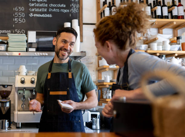istock Happy workers at a cafe talking and laughing 1445890831