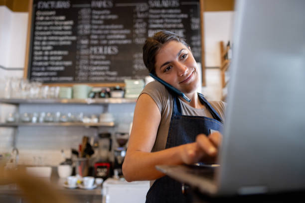 istock Restaurant hostess taking a reservation on the phone at a restaurant 1445890848