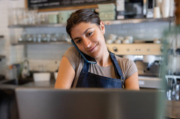 istock Waitress working at a cafe taking a delivery order on the phone 1445890853
