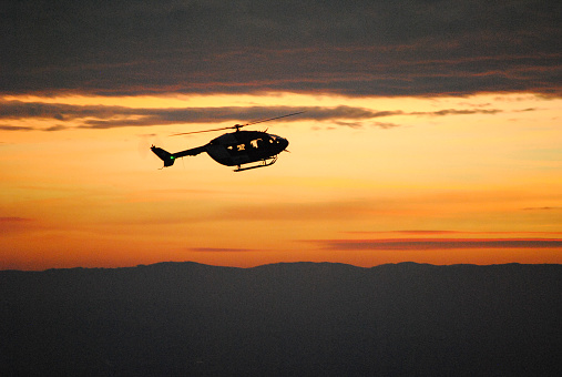 soldiers rescue helicopter operations on sunset sky background.