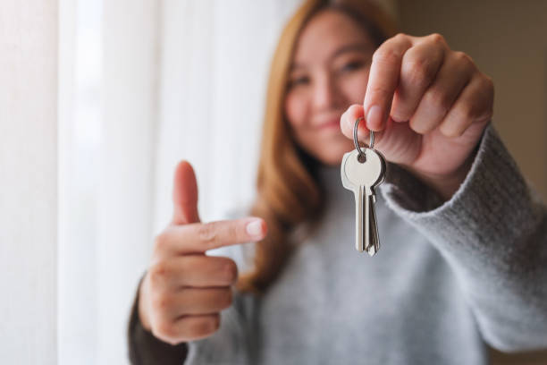 Blurred of a woman holding and pointing finger at the keys for real estate concept Blurred of a woman holding and pointing finger at the keys for real estate concept home ownership women stock pictures, royalty-free photos & images