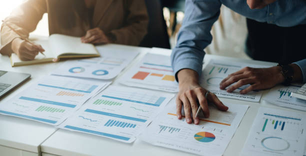 istock Two business asian people working in the office discussing documents and ideas from financial report paperwork at meeting 1445894682