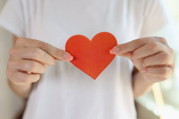 istock Female hands holding cute red paper hearts 1445898929
