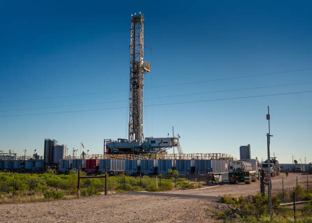 Oil drilling rig derrick platform structure with blue sky background. Heavy industrial operation and energy business photo.