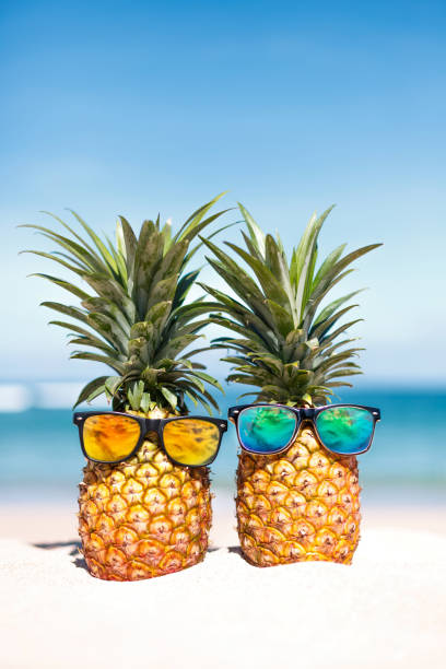 istock Two pineapples with trendy sunglasses in tropical paradise 1445901309