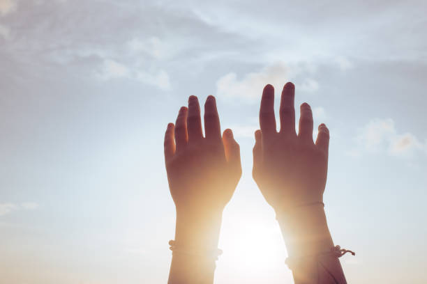 istock Women's hands raised up in front of the sunset 1445901420