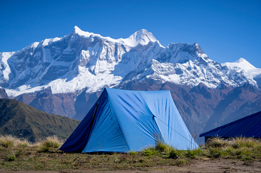 Blue camping tent in the mountains in a sunny day for a naturalistic screen saver. Solitude concept. Travelling concept
