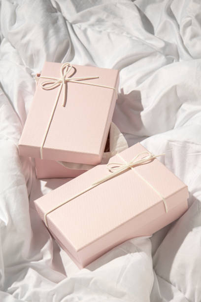 istock Two light pink gift boxes on a crumpled white cloth. Top view, flat lay 1445908659