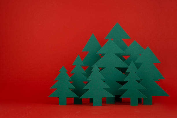istock Bright Christmas background with paper green spruce forest on red backdrop in minimalist modern style, copy space. New year scene for presentation products and advertising text, card, poster, flyer. 1445910374