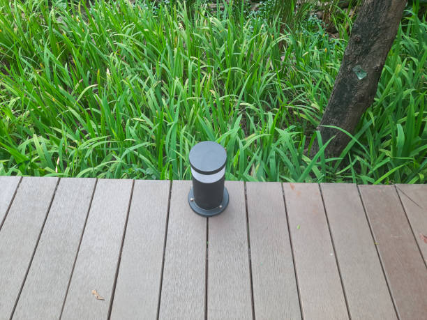 istock Floor lamp on wooden deck with plants background 1445912688