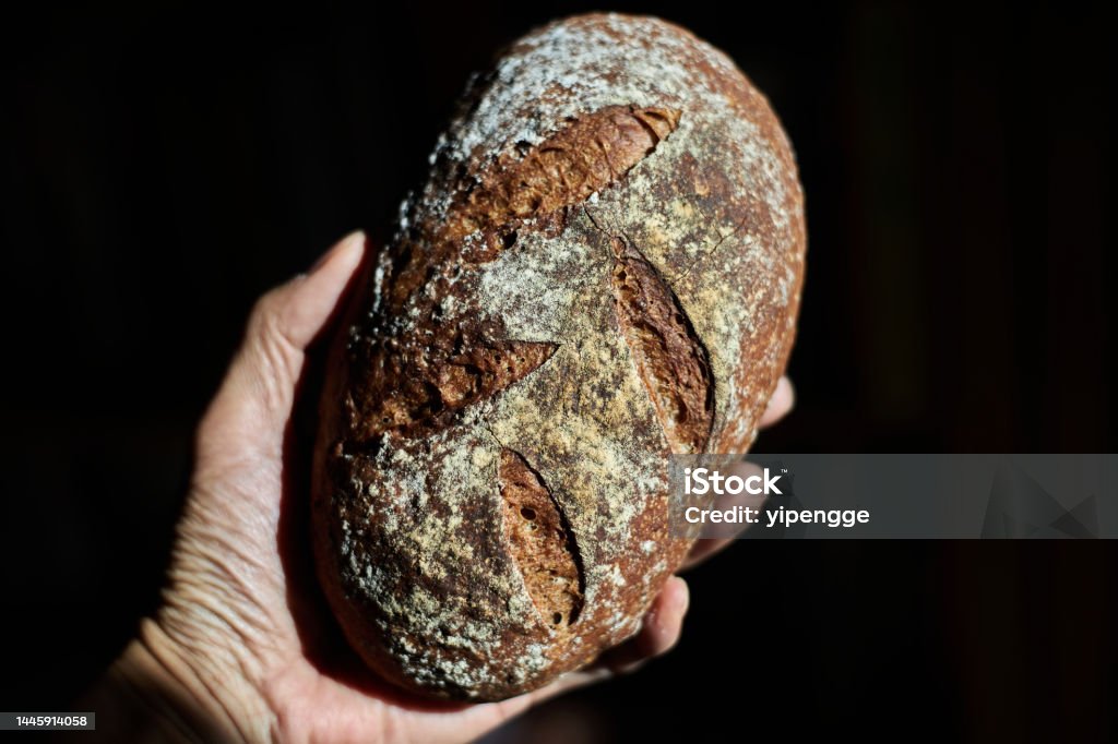 hand holding artisan rye bread Artisanal Food and Drink Stock Photo