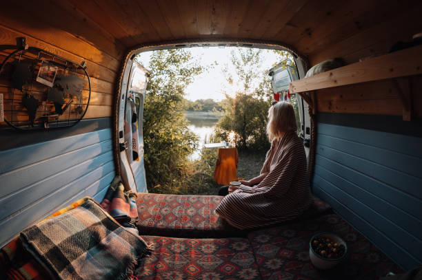 Woman enjoys coffee from her van