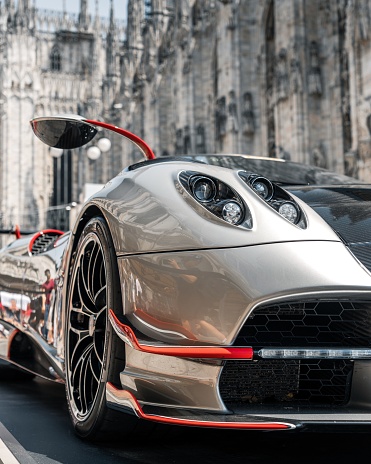 Milano, Italy – June 15, 2022: A vertical shot of gray shiny luxurious Pagani Zonda car with the Milan cathedral in the background