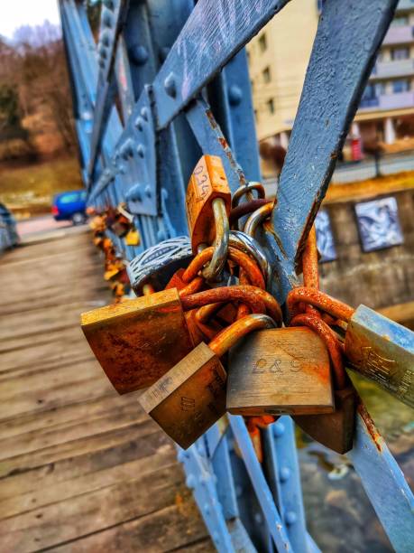 istock Vertical closeup of rusty metallic padlocks on a wooden bridge 1445917812