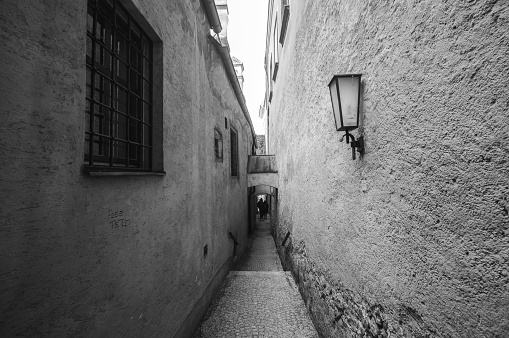 A grayscale shot of a narrow street in an old town in Austria.