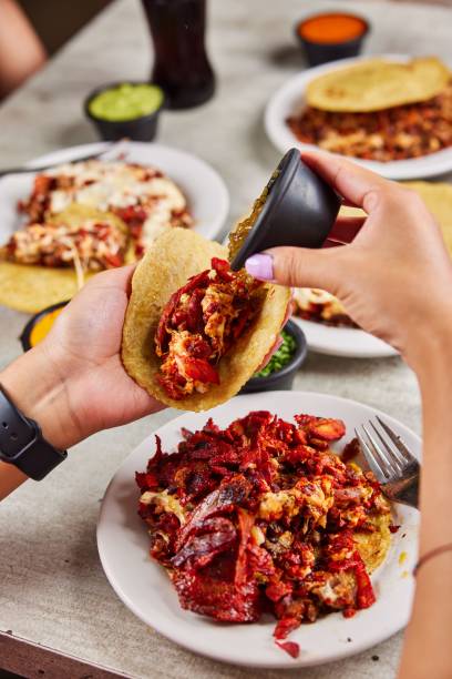 istock Vertical shot of a hand adding toppings onto a soft taco with meat 1445919440