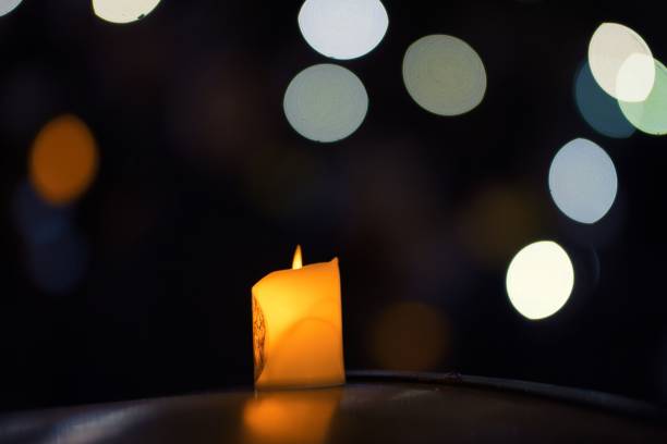 primer plano de la luz de una vela con un fondo bokeh - mass murder fotografías e imágenes de stock