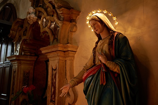 A statue of the Virgin Mary in a temple with lights