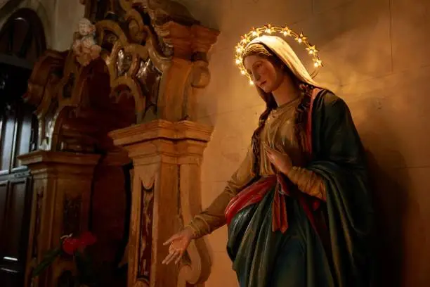 Photo of Statue of the Virgin Mary in a temple with lights