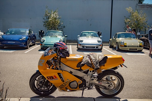 Santa Cruz, United States – August 15, 2022: A custom yellow FZR400 motorcycle parked in front of sports cars in a parking lot