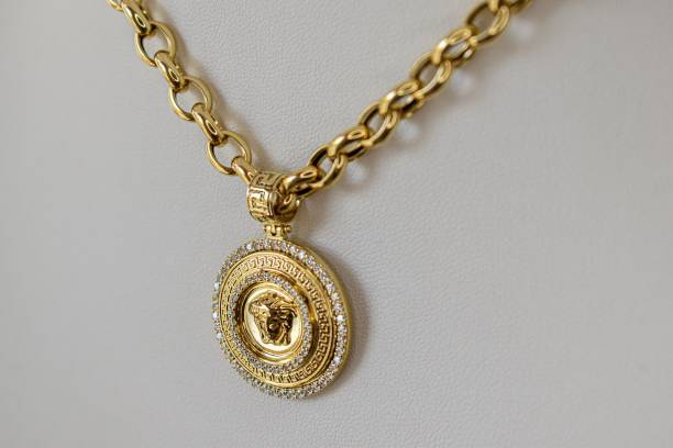 istock Golden chain necklace with medallion on white surface 1445925299