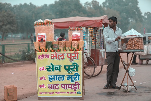 Anandpur Sahib, Punjab, India - March 2022: An indian seller selling the souvenir and food item on the streets of anandpur sahib during the hola mohalla festival.