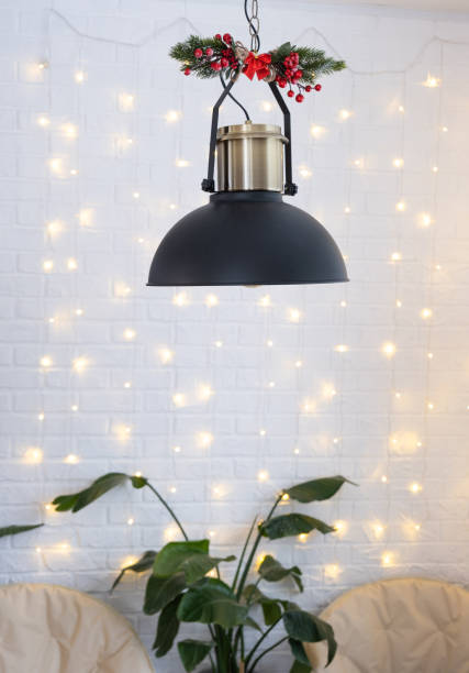 Christmas interior of a loft-style house with a black decorated retro lampshade and indoor plants of Strelitzia nicolai. New Year, comfort at home stock photo