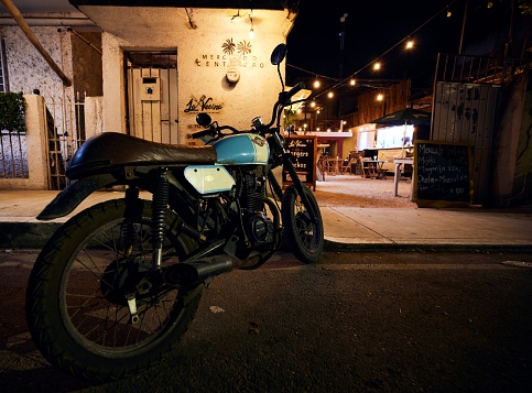 Tulum, Mexico – July 13, 2021: A classic vintage motorbike parked on the side of the street, closeup