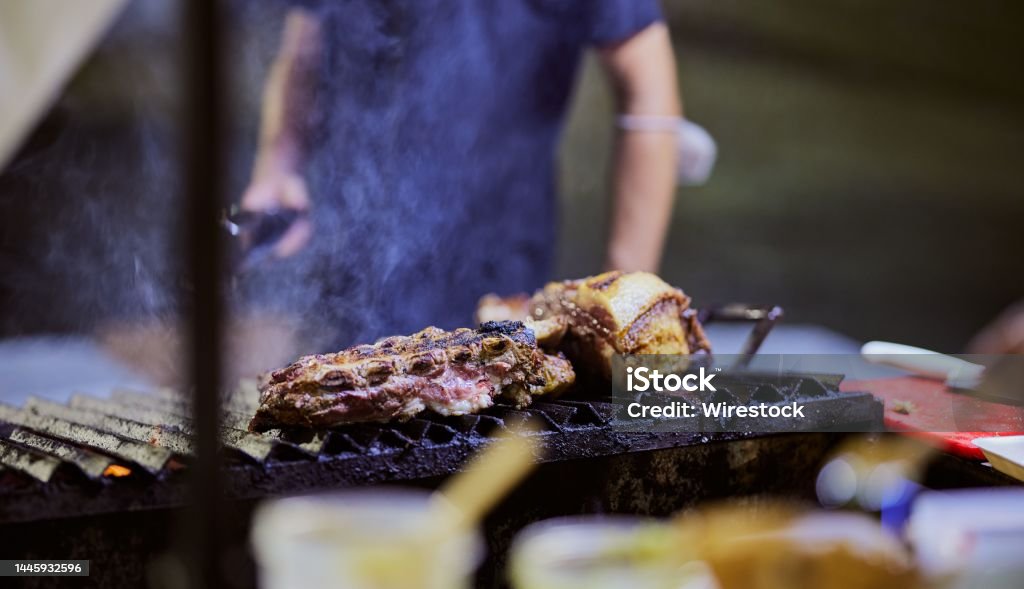Selective focus shot of meat cooking on a smoking griller A selective focus shot of meat cooking on a smoking griller Barbecue - Meal Stock Photo