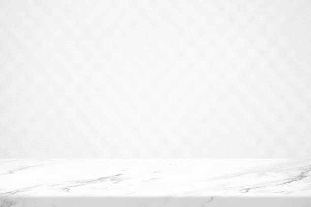 istock Marble Table with White Concrete Wall Texture Background with Light Beam and Shadow of Metal Chain Fence, Suitable for Product Presentation Backdrop, Display, and Mock up. 1445933184