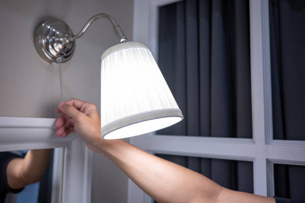 istock Male hand turn off the light on wall lamp 1445933728