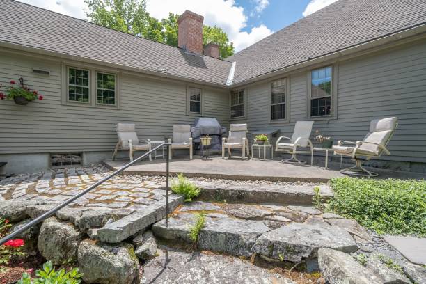istock Stone patio with armchairs attached to a white house 1445934446