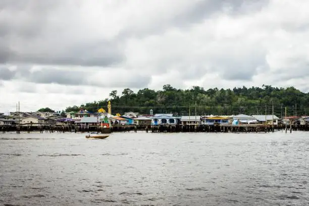 Photo of Landscape view of the buildings in the water village with boats nearby on a clouded day