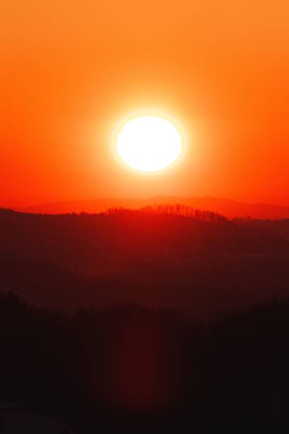 istock Vertical shot of a red cloudless sunset above the forest mountains 1445934667