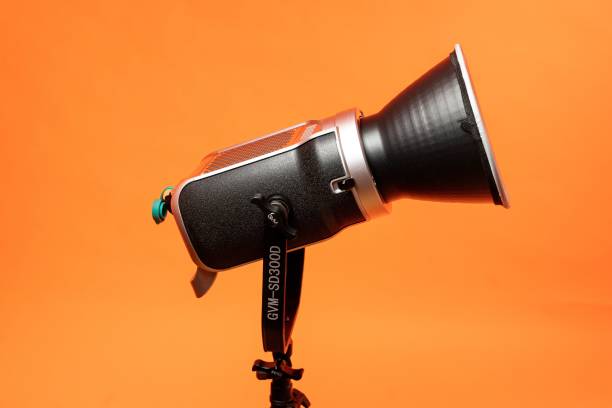istock Studio video light, continuous lighting for photo and video shooting on tripod, on orange background 1445935088