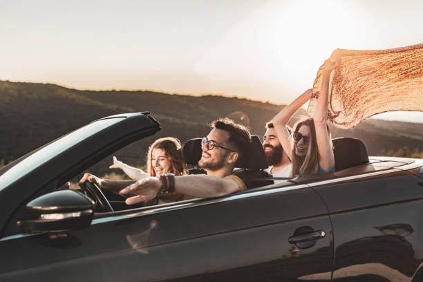 istock Carefree couples having fun in during summertime a convertible car. 1445938318