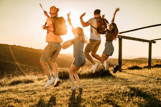 istock Rear view of playful friends having fun while jumping at sunset. 1445939116