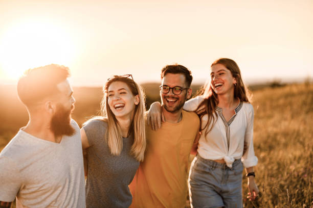 istock Happy embraced friends talking and walking on a hill at sunset. 1445939135