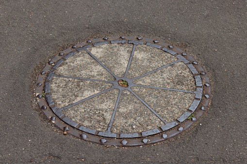 Old manhole cover in a street.